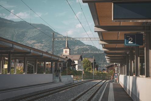 Gleis mit Sicht auf bewaldeten und besiedelten Berg