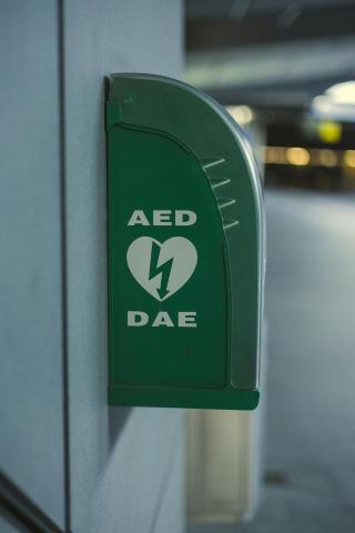 Grüner an der Wand hangender Defibrillator